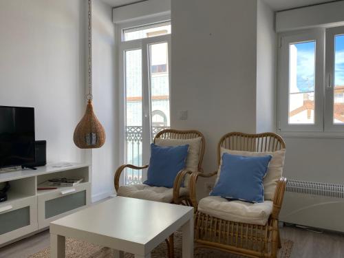a living room with two chairs and a table at Casa Foz Marina in Figueira da Foz