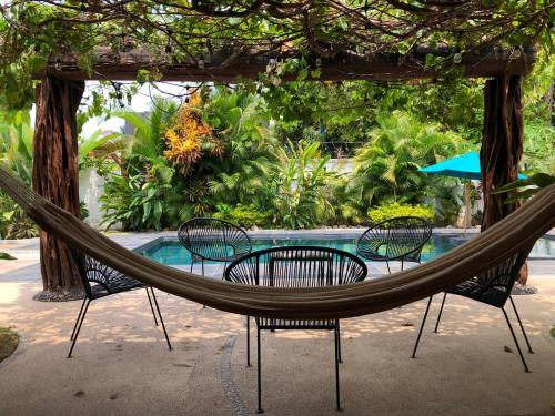 a hammock sitting in front of a pool at Casa Sirena in Ixtapa