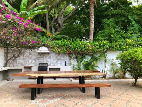 two wooden benches sitting next to a wall with flowers at Casa Sirena in Ixtapa