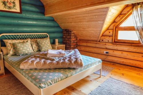 łóżko w pokoju w drewnianym domku w obiekcie Etno kuća Apartmani Pesma, Divčibare w mieście Divčibare