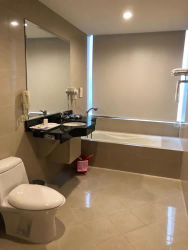 a bathroom with a toilet and a sink and a tub at Champion Hotel in Taipei