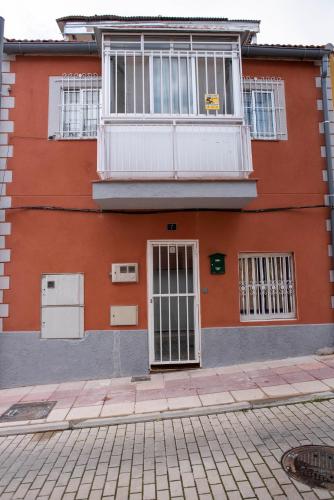 a red building with a door and a balcony at APARTAMENTO MADRID Norte in San Sebastián de los Reyes