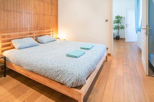 a bedroom with a bed with blue pillows on it at Saint Pauls Apartments in Antwerp