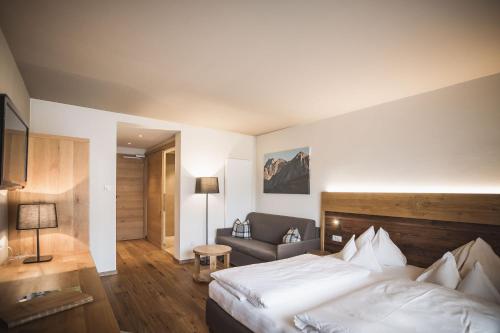 a hotel room with a bed and a couch at Autentis in Rasùn di Sotto