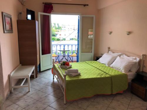 een slaapkamer met een groen bed en een raam bij Elli Rooms in Patitiri
