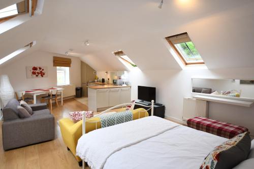 een slaapkamer met een bed en een woonkamer bij The Coach House Studio Apartment in Leamington Spa