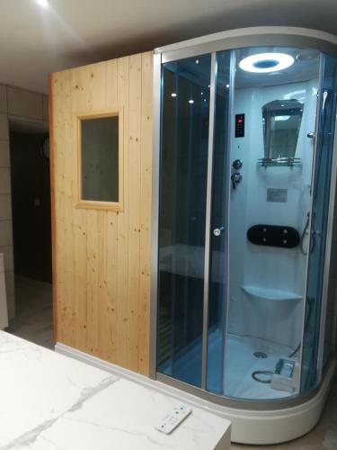 - une douche avec une porte en bois dans l'établissement appartement avec Jacuzzi hammam sauna privatisé au rez de chaussée ds maison à Voglans à 2 kilomètres du lac du bourget en Savoie entre Chambéry et Aix les Bains cure thermale, à Voglans