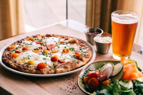 a pizza on a table with a glass of beer at Hyatt Regency Orlando International Airport Hotel in Orlando