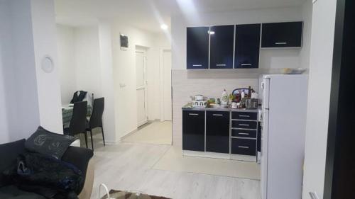 a kitchen with black cabinets and a white refrigerator at Apartman Centar Novi Grad in Bosanski Novi