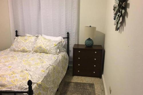 a bedroom with a bed and a dresser with a lamp at Chill Family and Friend Escape with Wrap Around Porch in Rio Grande