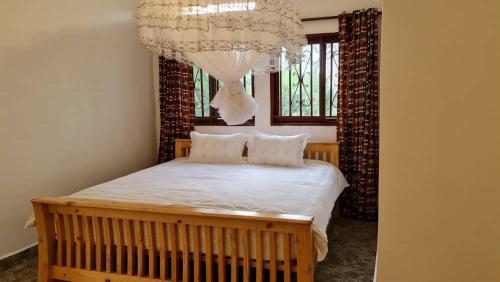 a bedroom with a bed with a chandelier at GKAT Resort in Mbarara