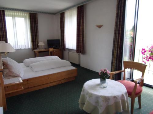 a bedroom with a bed and a table with a vase on it at Hotel Landgasthof Hacker in Zachenberg