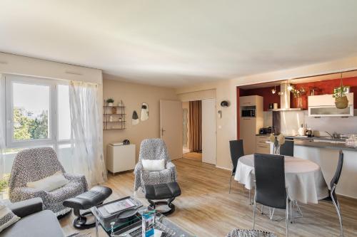 un salon avec une table et des chaises et une cuisine dans l'établissement Ty Marie by Cocoonr, à Rennes