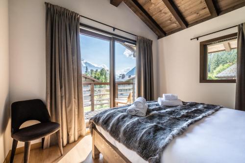 une chambre avec un lit et une grande fenêtre dans l'établissement Chalet Jatoba Chamonix - by EMERALD STAY, à Chamonix-Mont-Blanc
