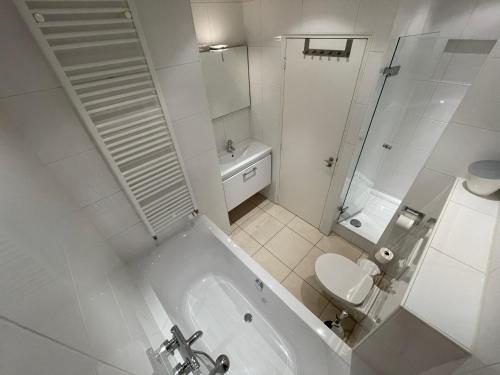 baño blanco con bañera y aseo en Wintergroen 11 en Julianadorp