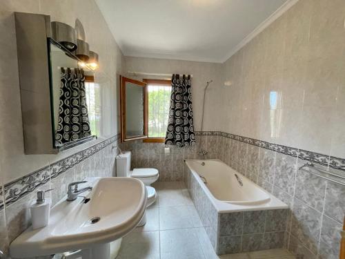 łazienka z 2 umywalkami, wanną i toaletą w obiekcie Villa Patricia w mieście Benitachell
