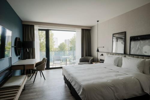 a hotel room with a large bed and a balcony at Radisson Resort Kołobrzeg in Kołobrzeg