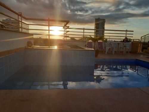 a pool on the roof of a building with the sun setting at SAMIR HOTEL COMFORT in Porto Velho