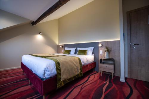 Cette chambre comprend un grand lit et un tapis rouge. dans l'établissement Le Vivier, à Amiens