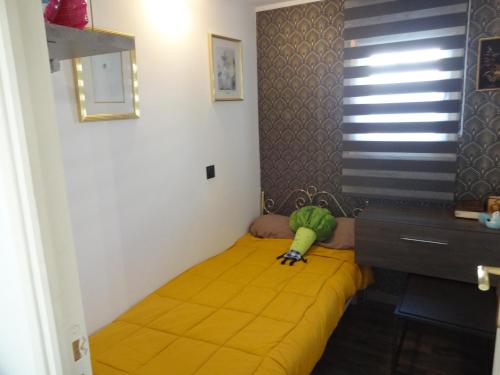 Cama pequeña en habitación con manta amarilla en Sud Cévennes, en Ganges
