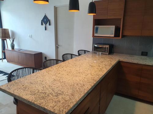 a kitchen with a counter with chairs and a microwave at Ximena Hotel Boutique in Sayulita