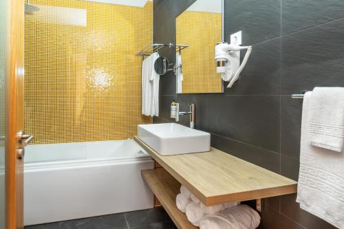 a bathroom with a sink and a bath tub at Villas do Mar in Faja Grande