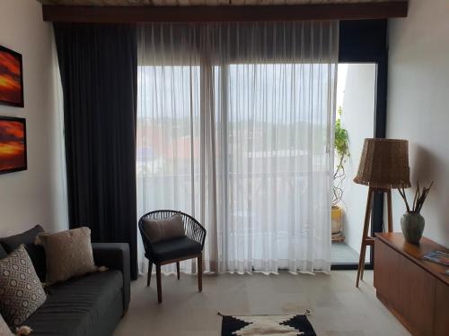 a living room with a couch and a window at Ximena Hotel Boutique in Sayulita