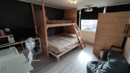 een kamer met 2 stapelbedden en een bureau bij Chill & Party in Breda