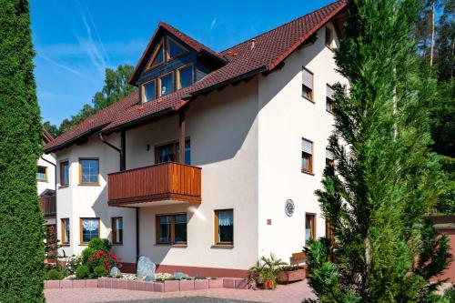 Cette grande maison blanche dispose d'un balcon. dans l'établissement Ferienwohnung Hauk, à Laudenbach