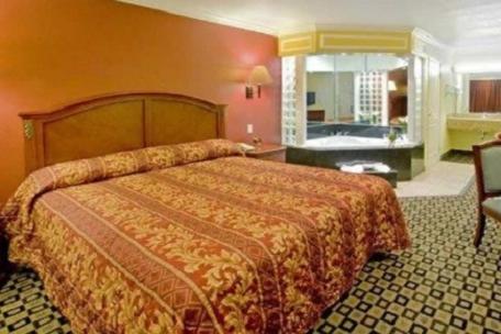 a hotel room with a bed and a bathroom at Americas Best Value Inn San Bernardino in San Bernardino