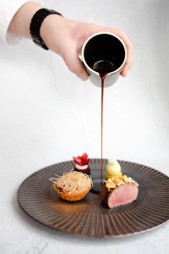 a person holding a cup of coffee next to a plate of food at Boutique Hotel 't Lansink in Hengelo