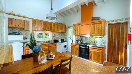 a kitchen with wooden cabinets and a wooden table at Challet Miradouro do Vale in Furnas