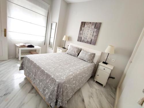 a white bedroom with a bed and a window at Santa Justa Sevilla Nervion Buhaira Centro in Seville