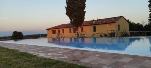 a villa with a swimming pool in front of a house at Agriturismo Cheloni in Guasticce