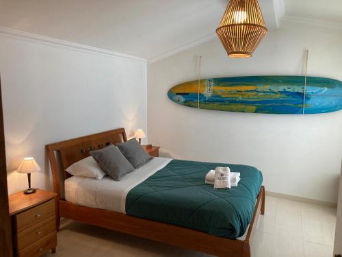 een slaapkamer met een bed en een schilderij aan de muur bij Best Houses 45 - Beautiful ocean and city view in Peniche