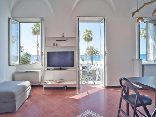ein Wohnzimmer mit einem TV, einem Tisch und Stühlen in der Unterkunft Medusa Apartment - Piazza 1 in Finale Ligure