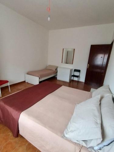 a bedroom with a large bed and a chair at White beach Le Castella in Le Castella