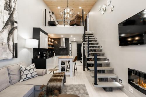 uma sala de estar com uma escada que leva até um loft em Le ChiK by Gestion ELITE em Mont-Tremblant