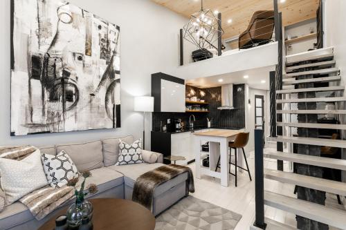 Le ChiK by Gestion ELITE في مونت تريمبلانت: غرفة معيشة مع درج يؤدي إلى المطبخ