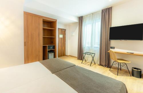 a hotel room with a large bed and a desk at DWO Nopal in Puerto de la Cruz