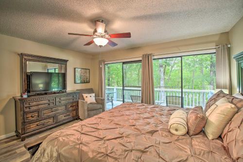 a bedroom with a bed and a television and a balcony at Hot Springs House with Spacious Deck and Grill! in Hot Springs Village