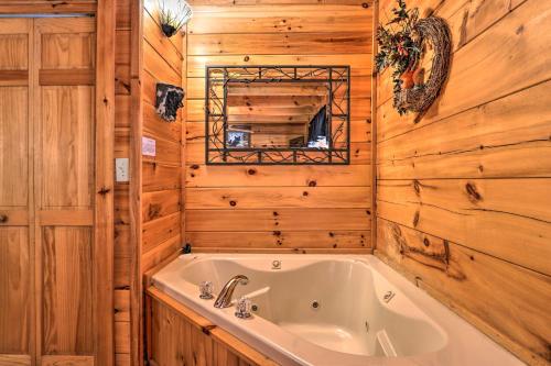 a bath tub in a room with wooden walls at Pigeon Forge Getaway with Covered Patio and Hot Tub! in Pigeon Forge