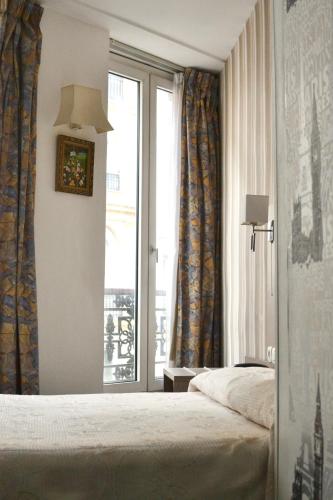 une chambre d'hôtel avec un lit et une fenêtre dans l'établissement Hotel Royal Bergère, à Paris