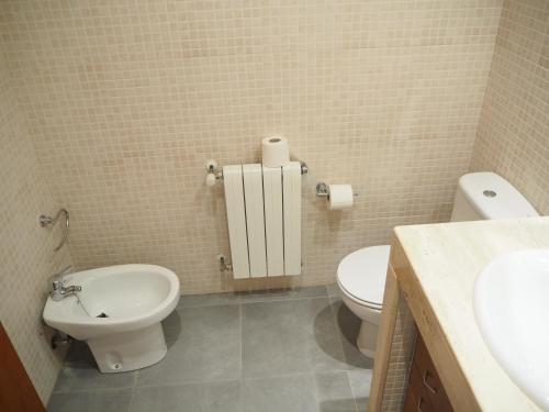 a bathroom with a toilet and a sink at Casa l'Escala, piscina comuntària i jardí privat in L'Escala