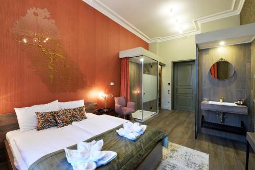 a bedroom with a bed and a bathroom with a sink at 1552 Boutique Hotel in Eger