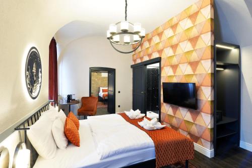a bedroom with a large bed and a tv at 1552 Boutique Hotel in Eger