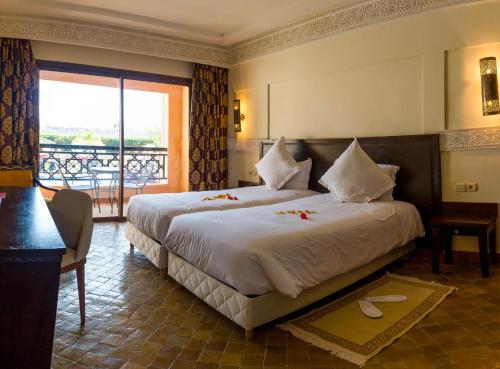a hotel room with two beds and a balcony at Club Paradisio in Marrakech