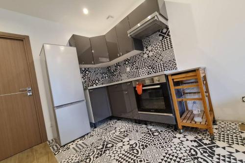 - une cuisine avec du carrelage noir et blanc sur le mur dans l'établissement Magnifique T2 dans une maison neuve d'architecte / Magnificent T2 in a new architect house, à Asnières-sur-Seine