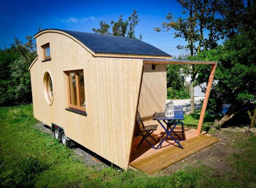 een tiny house met een tafel op een dek bij Tiny Côte d’Opale in Audresselles