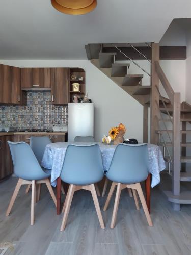 a kitchen with a table and four blue chairs at Domek Nieledwia in Milówka